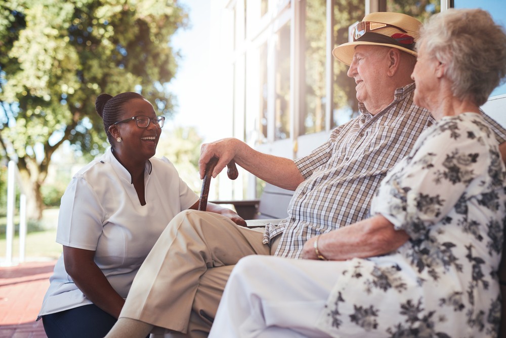 staff member talking to senior couple about independent vs assisted living communities