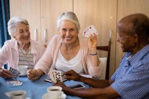Conservatory At Champion Forest Residents Enjoying Card Game