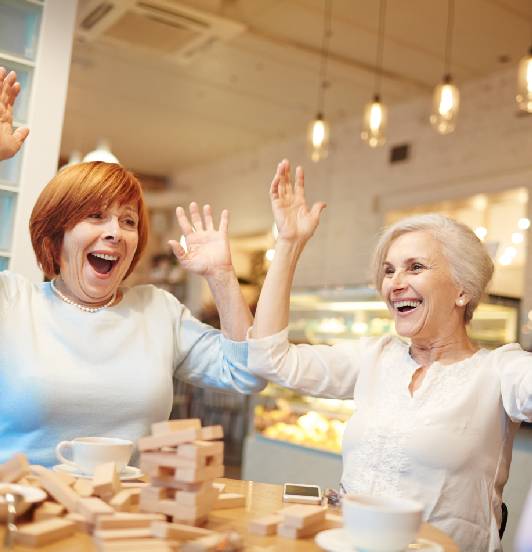 Happy old woman playing block game at table