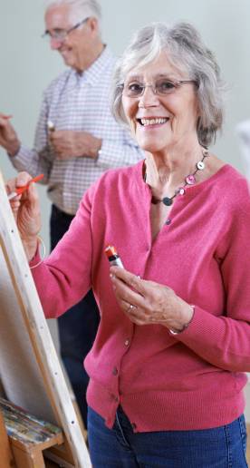 Happy old woman learn painting on the painting class