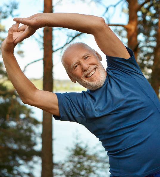 Happy old man doing yoga outdoor